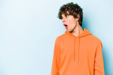 Kafkasyalı genç adam mavi arka planda izole edilmişti. Gördüğü bir şey yüzünden şok olmuştu..