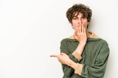 Beyaz arka planda izole edilmiş genç beyaz adam yan tarafı işaret ediyor