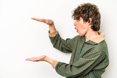 Beyaz arka planda izole edilmiş genç beyaz adam elleri arasında bir kopya alanı tutarken şok ve hayrete düştü..