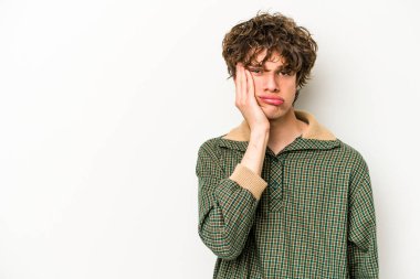 Beyaz arka planda izole edilmiş, üzgün ve dalgın hisseden genç beyaz bir adam fotokopi alanına bakıyor..