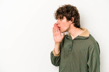 Beyaz arka planda izole edilmiş genç beyaz bir adam gizli bir sıcak fren haberi veriyor ve yana bakıyor.