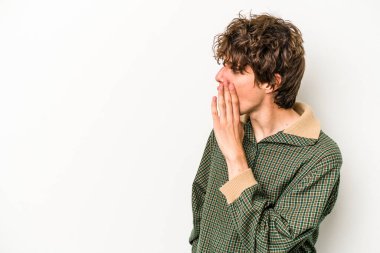 Beyaz arka planda izole edilmiş genç beyaz adam gördüğü bir şey yüzünden şoka uğruyor..