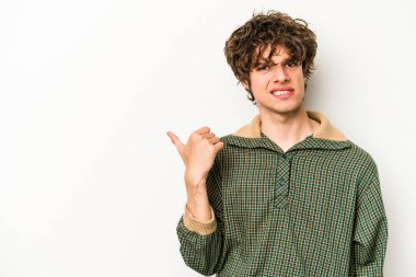 Beyaz arka planda izole edilmiş genç beyaz bir adam işaret parmağıyla fotokopi alanını işaret ederek şok oldu..