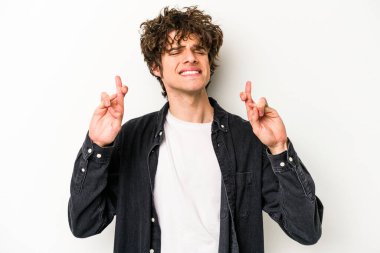 Beyaz arka planda izole genç beyaz adam şans dilemek için şans diliyor.