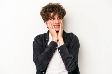 Beyaz arka planda izole edilmiş genç beyaz adam korkmuş ve korkmuş..