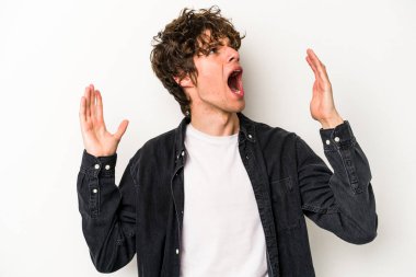 Beyaz arka planda izole edilmiş genç beyaz adam gökyüzüne haykırıyor, yukarı bakıyor, hayal kırıklığına uğramış..