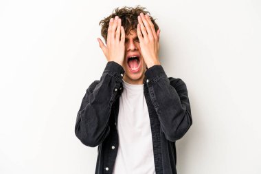 Beyaz arka planda izole edilmiş genç beyaz bir adam yüzünün yarısını palmiye ile örterek eğleniyor..