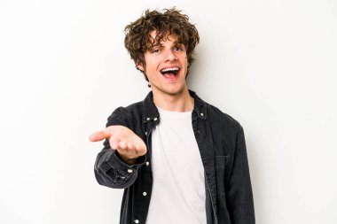 Beyaz arka planda izole edilmiş genç beyaz bir adam selamlama jesti olarak kameraya elini uzatıyor..