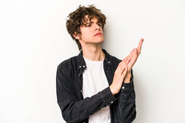 Beyaz arka planda izole olmuş genç beyaz bir adam enerjik ve rahat hissediyor, ellerini ovuşturuyor..