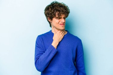 Mavi arka planda izole edilmiş genç beyaz adam virüs ya da enfeksiyon yüzünden boğazında ağrı hissediyor..