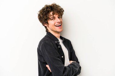 Beyaz arka planda kendini güvende hisseden, kararlılıkla kollarını kavuşturan beyaz tenli genç bir adam..