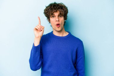 Kafkasyalı genç bir adam mavi arka planda izole edilmiş. Bir fikri, ilham verici bir fikri var..