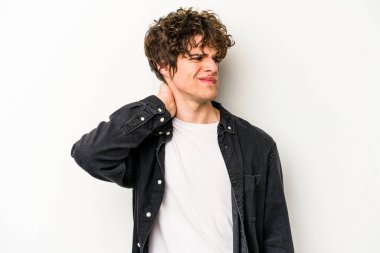 Beyaz arka planda izole edilmiş genç beyaz bir adam yorgun ve uykulu bir şekilde elini başının üstünde tutuyor..