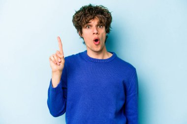 Kafkasyalı genç adam mavi arka planda izole edildi. Harika bir fikri var, yaratıcılık kavramı..