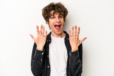 Beyaz arka planda izole edilmiş beyaz tenli genç adam on numarayı elleriyle gösteriyor..