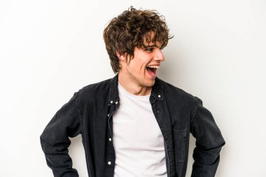 Beyaz arka planda izole genç beyaz adam mutlu bir şekilde gülüyor ve ellerini karnının üstünde tutarak eğleniyor..