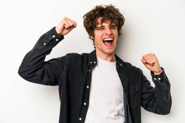 Beyaz arka planda izole edilmiş genç beyaz adam tasasız ve heyecanlı bir şekilde tezahürat yapıyor. Zafer konsepti.