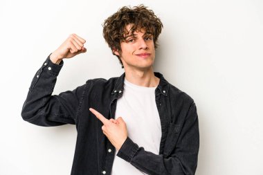 Beyaz arka planda izole edilmiş genç beyaz bir adam güçlü bir hareket gösteriyor, kollarıyla, kadınsı gücün sembolü.