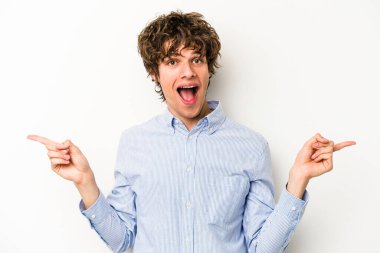 Beyaz arka planda izole edilmiş genç beyaz bir adam farklı kopya alanlarını gösteriyor, birini seçiyor, parmaklarıyla gösteriyor..