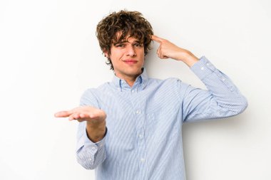 Beyaz arka planda izole edilmiş genç beyaz bir adam elinde bir ürün tutuyor ve.