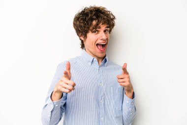 Beyaz arka planda izole edilmiş genç beyaz adam parmaklarıyla ön tarafı işaret ediyor..