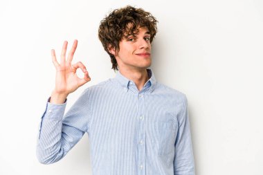 Beyaz arka planda izole edilmiş genç beyaz bir adam bir göz kırptı ve elleriyle iyi bir jest yaptı..