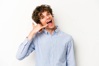 Beyaz arka planda izole edilmiş genç beyaz bir adam parmakları olan bir cep telefonu hareketi gösteriyor..