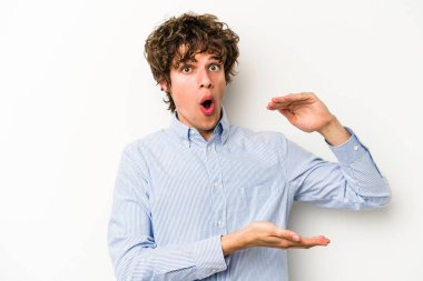 Beyaz arka planda izole edilmiş beyaz bir adam iki eliyle bir şey tutuyor..