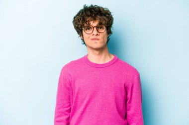 Kafkasyalı genç adam mavi arka planda izole edilmiş üzgün, ciddi yüzlü, mutsuz ve hoşnutsuz..