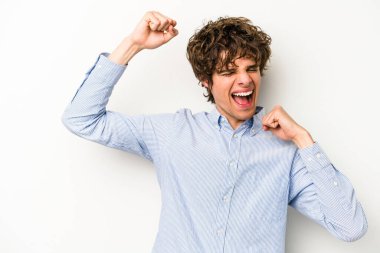 Beyaz arka planda izole edilmiş genç beyaz bir adam zaferden sonra yumruğunu kaldırıyor, kazanan konsept.