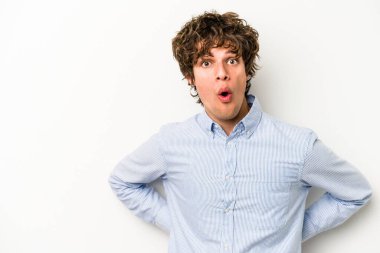 Beyaz arka planda izole edilmiş genç beyaz adam gördüğü bir şey yüzünden şoka uğruyor..