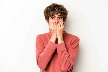 Beyaz arka planda izole edilmiş, tırnak yiyen, gergin ve endişeli genç bir beyaz adam..