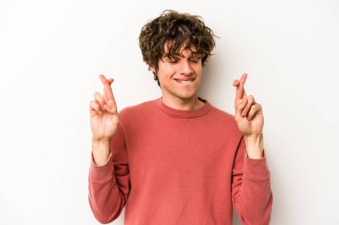 Beyaz arka planda izole genç beyaz adam şans dilemek için şans diliyor.