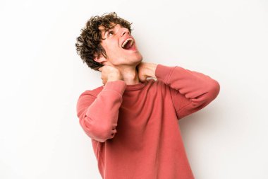 Beyaz arka planda izole olmuş genç beyaz bir adam kendini güvende hissediyor, elleri başının arkasında..