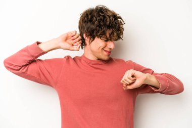 Beyaz arka planda izole edilmiş genç beyaz adam kollarını uzatıyor, rahat bir konumda..