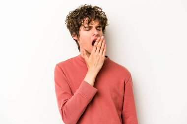Beyaz arka planda izole edilmiş genç beyaz adam esniyor. Ağzı eliyle kapatan yorgun bir hareket sergiliyor..