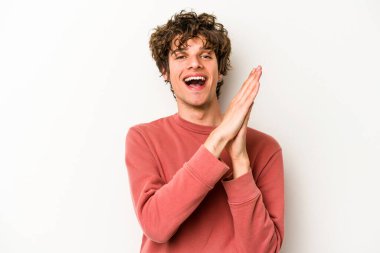 Beyaz arka planda izole olmuş genç beyaz bir adam enerjik ve rahat hissediyor, ellerini ovuşturuyor..