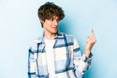 Kafkasyalı genç adam mavi arka planda izole edilmiş seni işaret ediyor sanki davet ediliyormuş gibi..