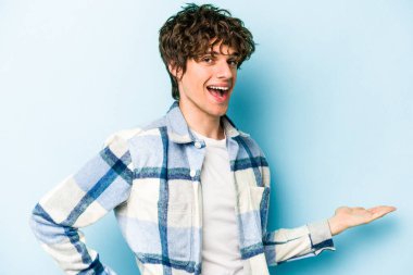 Mavi arka planda izole edilmiş beyaz bir genç hoş bir yüz ifadesi sergiliyor..