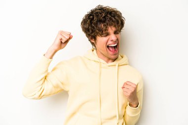 Beyaz arka planda izole edilmiş genç beyaz adam tasasız ve heyecanlı bir şekilde tezahürat yapıyor. Zafer konsepti.