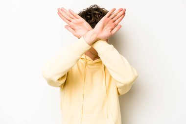 Beyaz arka planda izole genç beyaz adam iki kolu çapraz tutuyor, inkar kavramı.