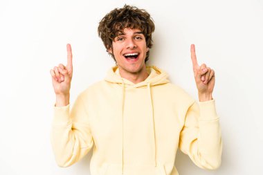 Beyaz arka planda izole genç beyaz adam işaret iki ön parmakları boş bir boşluk gösteren.