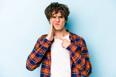 Mavi arka planda izole genç beyaz adam güçlü bir diş ağrısı, azıdişi ağrısı var..