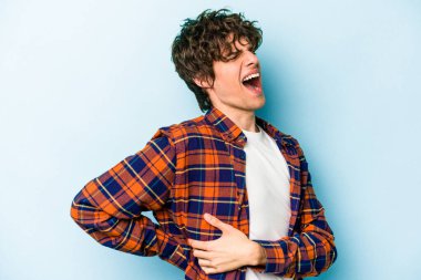 Mavi arka planda izole edilmiş beyaz bir adam sırt ağrısı çekiyor..