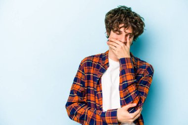 Kafkasyalı genç adam mavi arka planda yalnızdı gülerek, kaygısızca, doğal duygularla.