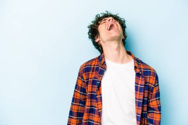 Kafkasyalı genç adam mavi arka planda izole edilmiş. Çok kızgın, öfkeli, hayal kırıklığına uğramış..