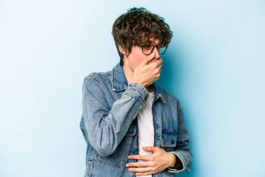 Kafkasyalı genç adam mavi arka planda izole edilmiş korkmuş ve korkmuş..