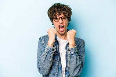 Mavi arka planda izole edilmiş genç beyaz adam gergin elleriyle çığlık atıyor..
