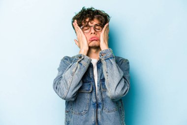 Kafkasyalı genç adam mavi arka planda izole edilmiş sızlanıyor ve ağlıyordu..