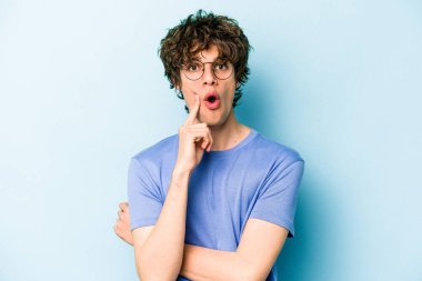 Kafkasyalı genç adam mavi arka planda izole edildi. Harika bir fikri var, yaratıcılık kavramı..